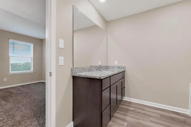 a bathroom with a granite countertop sink and a mirror