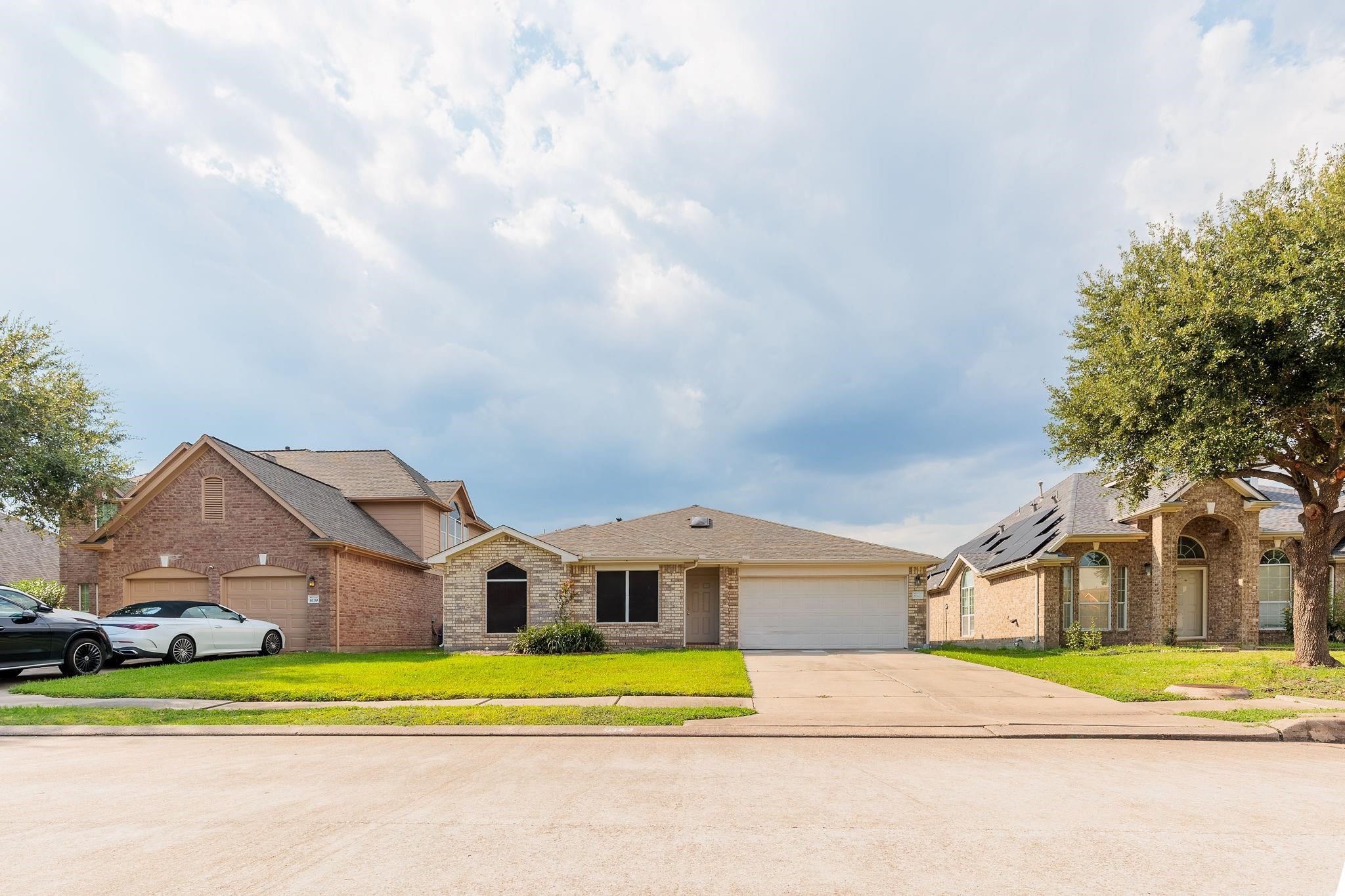 a front view of a house with a yard and trees