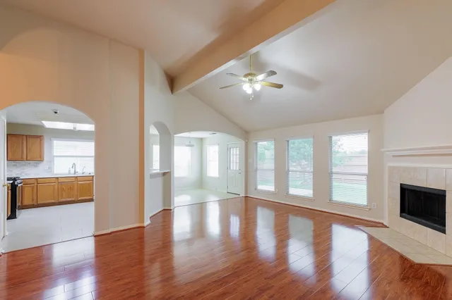 a view of an empty room with a window and wooden floor