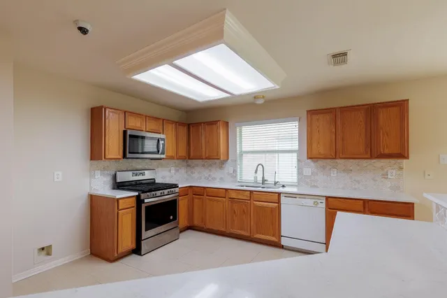 a kitchen with stainless steel appliances granite countertop a sink stove and microwave