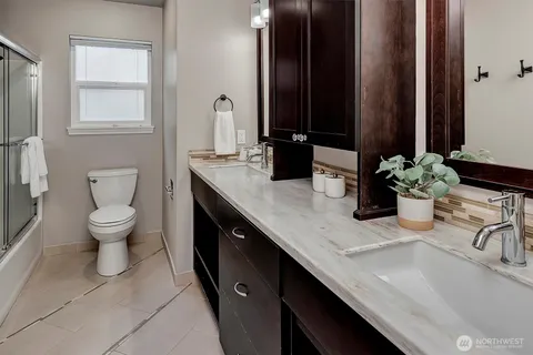 a bathroom with a granite countertop sink a toilet and mirror