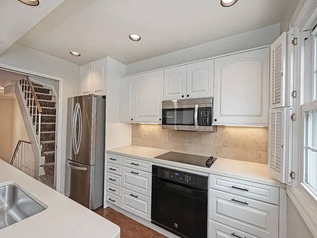 a kitchen with white cabinets and stainless steel appliances