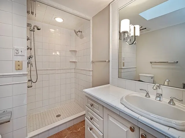 a bathroom with a sink a shower and a mirror