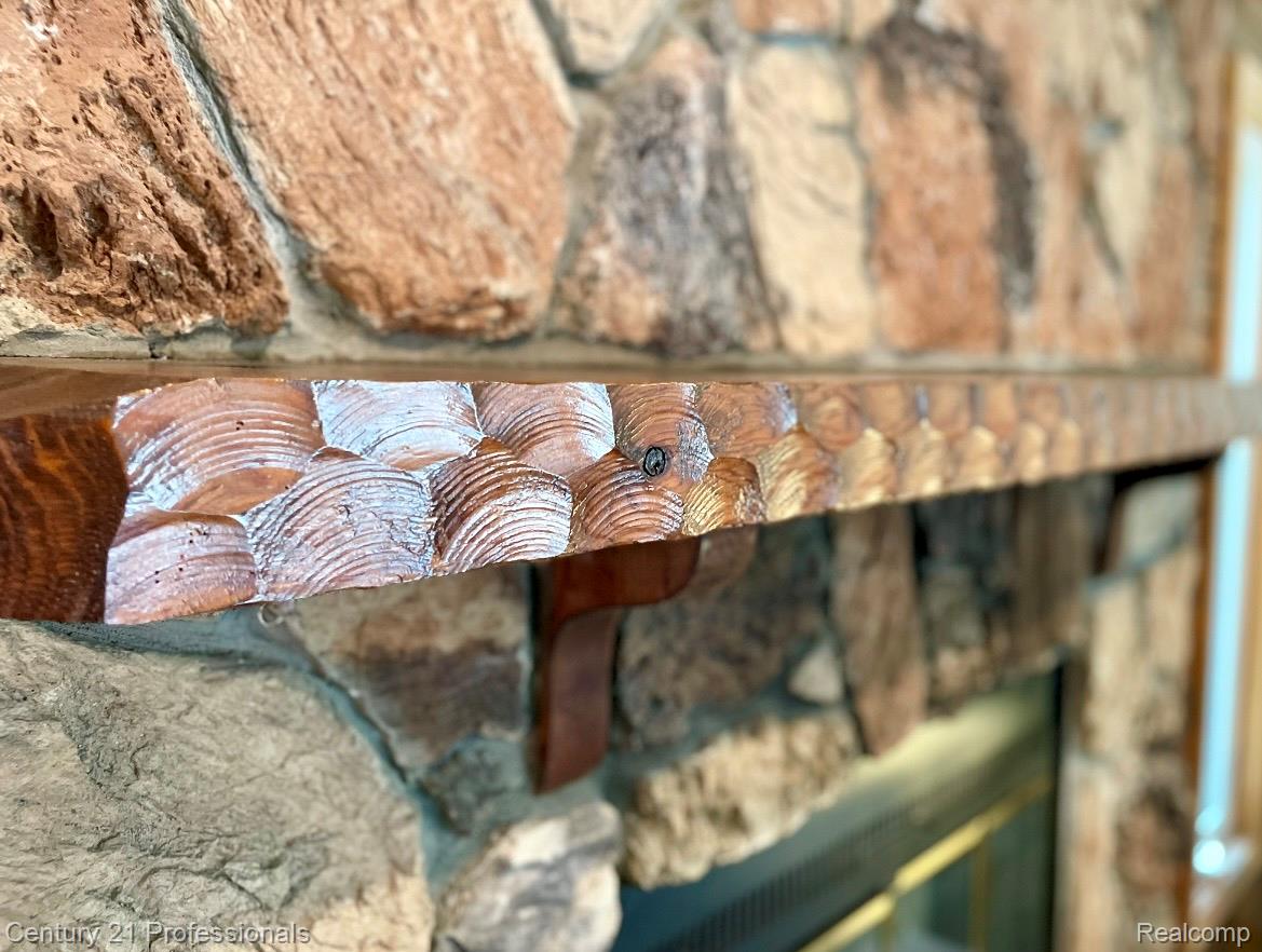 2903 Lake Angelus Road Waterford, MI 48329 - Photo 3 of 17 Stone fireplace featuring a carved wood mantel with decorative brackets and a modern firebox