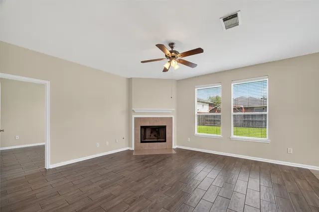 a view of an empty room with a fireplace and a window