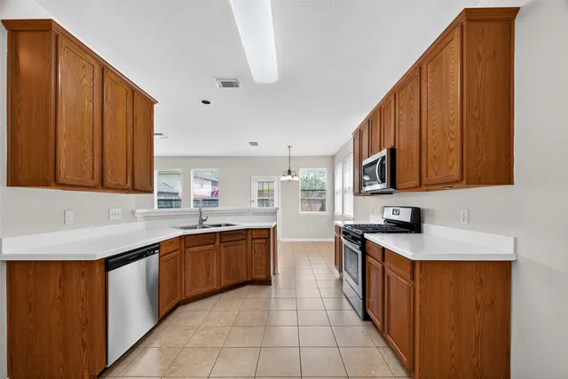 a kitchen with stainless steel appliances granite countertop a sink stove and cabinets