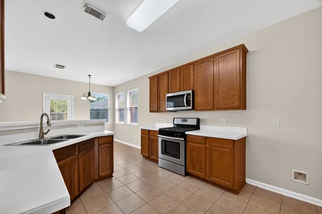 a kitchen with stainless steel appliances granite countertop a sink stove and cabinets