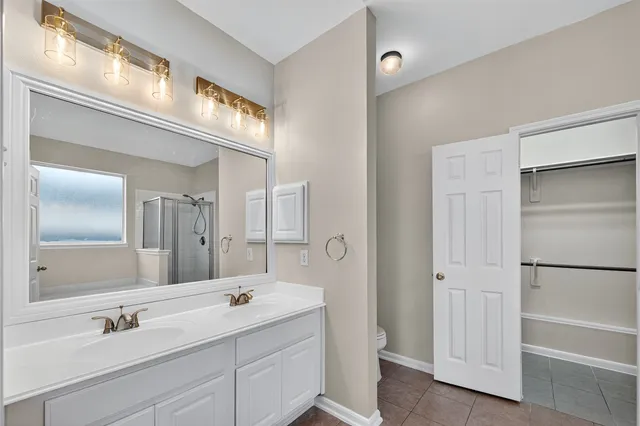 a bathroom with a double vanity sink a mirror and a bathtub