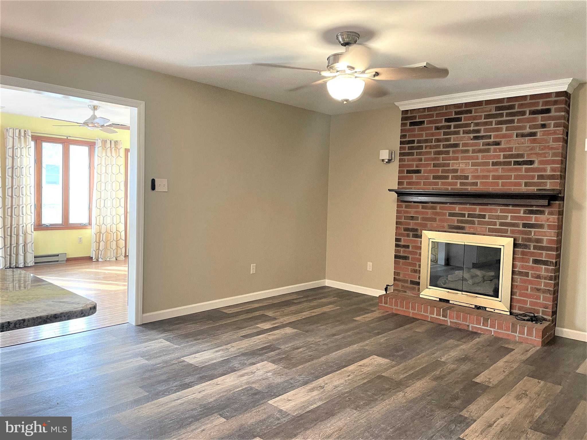 29 Georgia Road Pennsville, NJ 08070 - Photo 10 of 29 a view of a livingroom with a fireplace a ceiling fan and wooden floor
