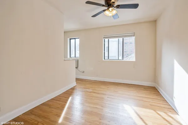 a view of empty room with wooden floor