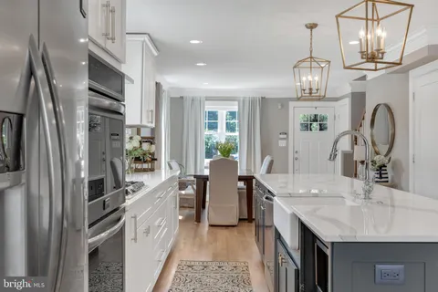 a kitchen with stainless steel appliances granite countertop a sink refrigerator and cabinets