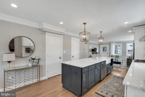 a large room with kitchen island a sink a stove and wooden floors