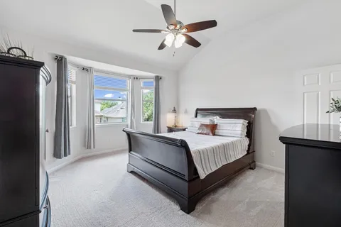 a bed room with a bed and a ceiling fan