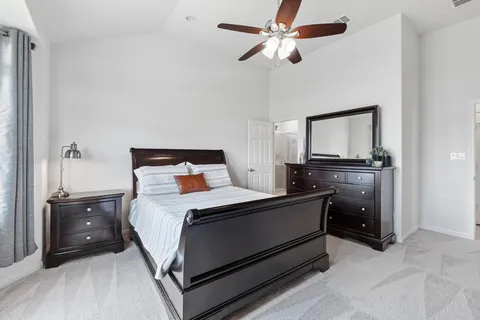 a bedroom with a bed and a flat tv screen on dresser