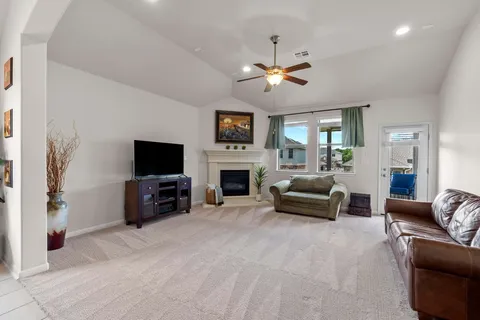 a living room with furniture a flat screen tv and a fireplace