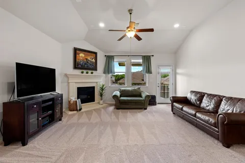 a living room with furniture a flat screen tv and a fireplace