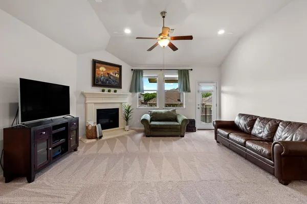 a living room with furniture a flat screen tv and a fireplace