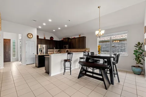 a kitchen with a table chairs refrigerator and microwave
