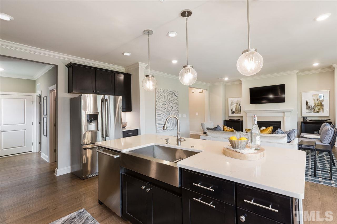 156 Ivory Lane, Unit 84 Raleigh, NC 27610 - Photo 13 of 30 a kitchen with a sink stainless steel appliances and wooden floor