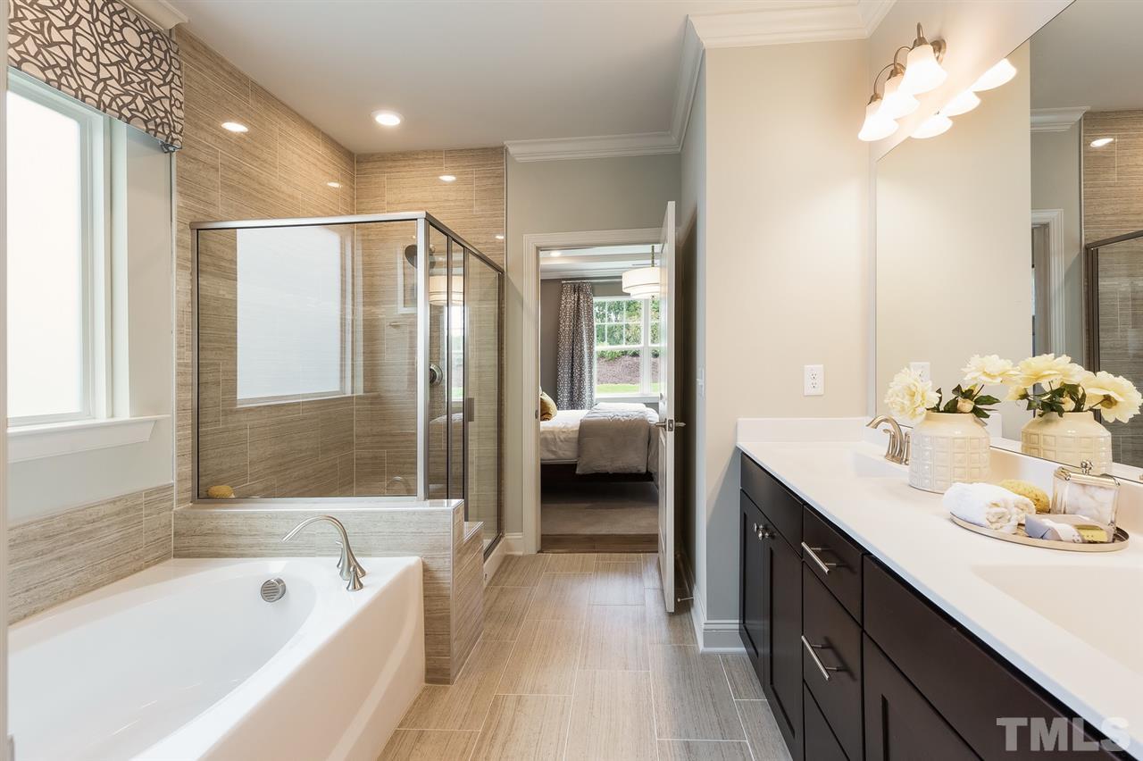 156 Ivory Lane, Unit 84 Raleigh, NC 27610 - Photo 21 of 30 a en suite spacious bathroom with a double vanity sink a large mirror and shower