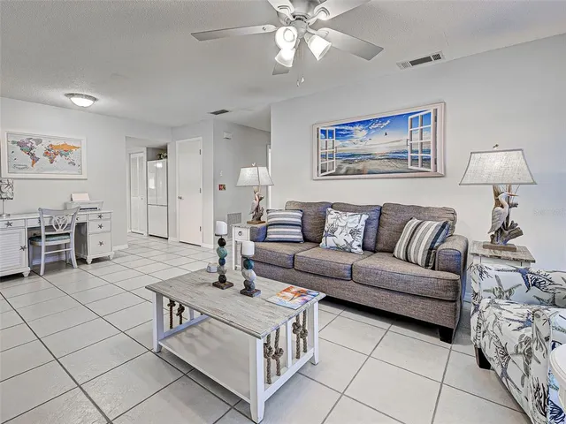 a living room with furniture a flat screen tv and a dining table