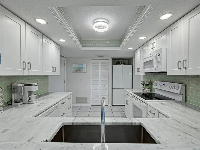 a kitchen with granite countertop white cabinets and sink