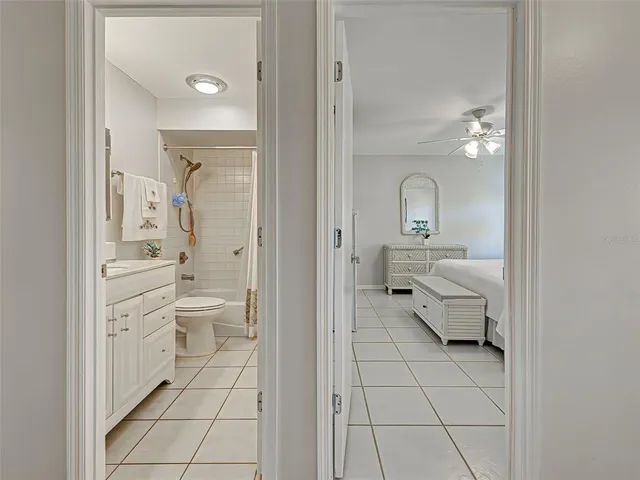 a bathroom with a toilet sink vanity granite and mirror