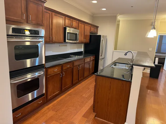 a kitchen with granite countertop a sink stove and refrigerator