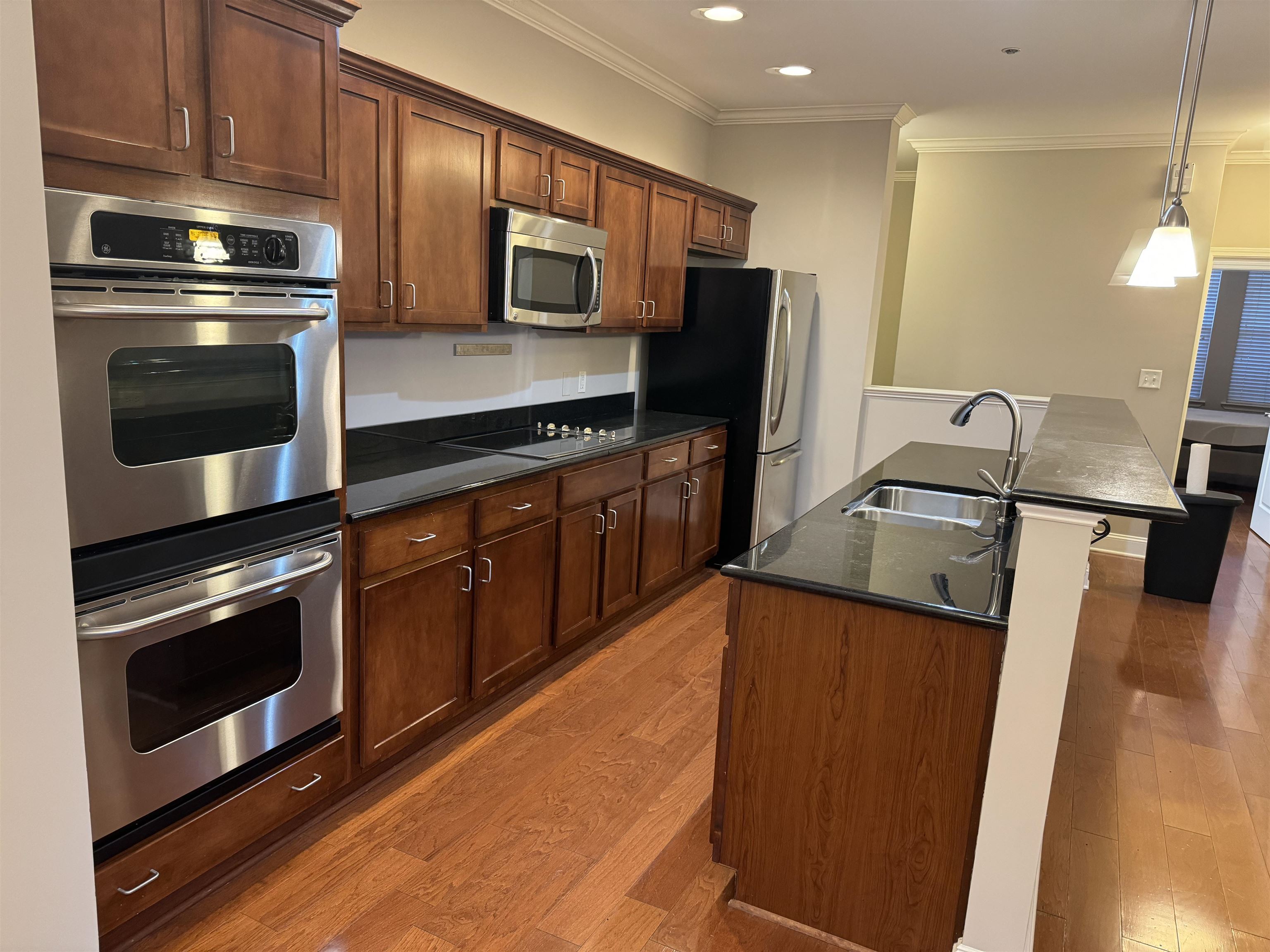 a kitchen with granite countertop a sink stove and refrigerator