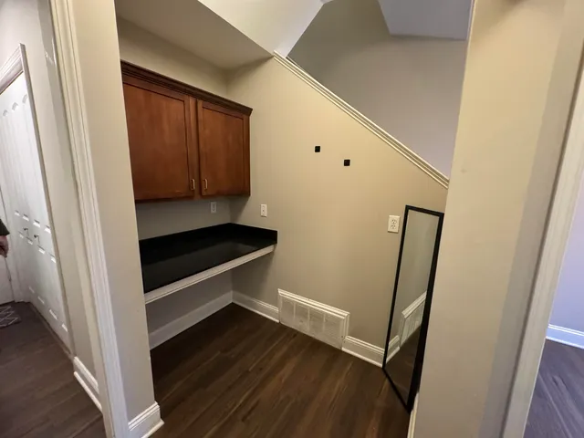 a view of a hallway with wooden floor and staircase