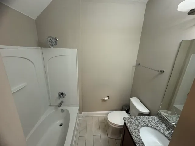 a white toilet sitting next to a bath tub
