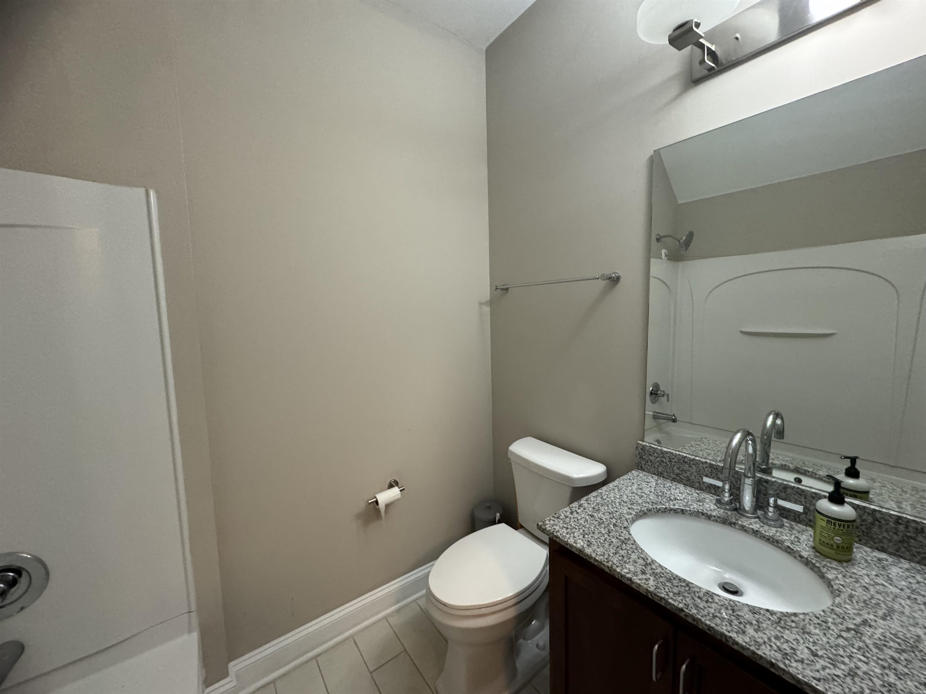 70 West Carolina Avenue, Unit 105 Memphis, TN 38103 - Photo 20 of 40 a bathroom with a granite countertop toilet a sink and a mirror