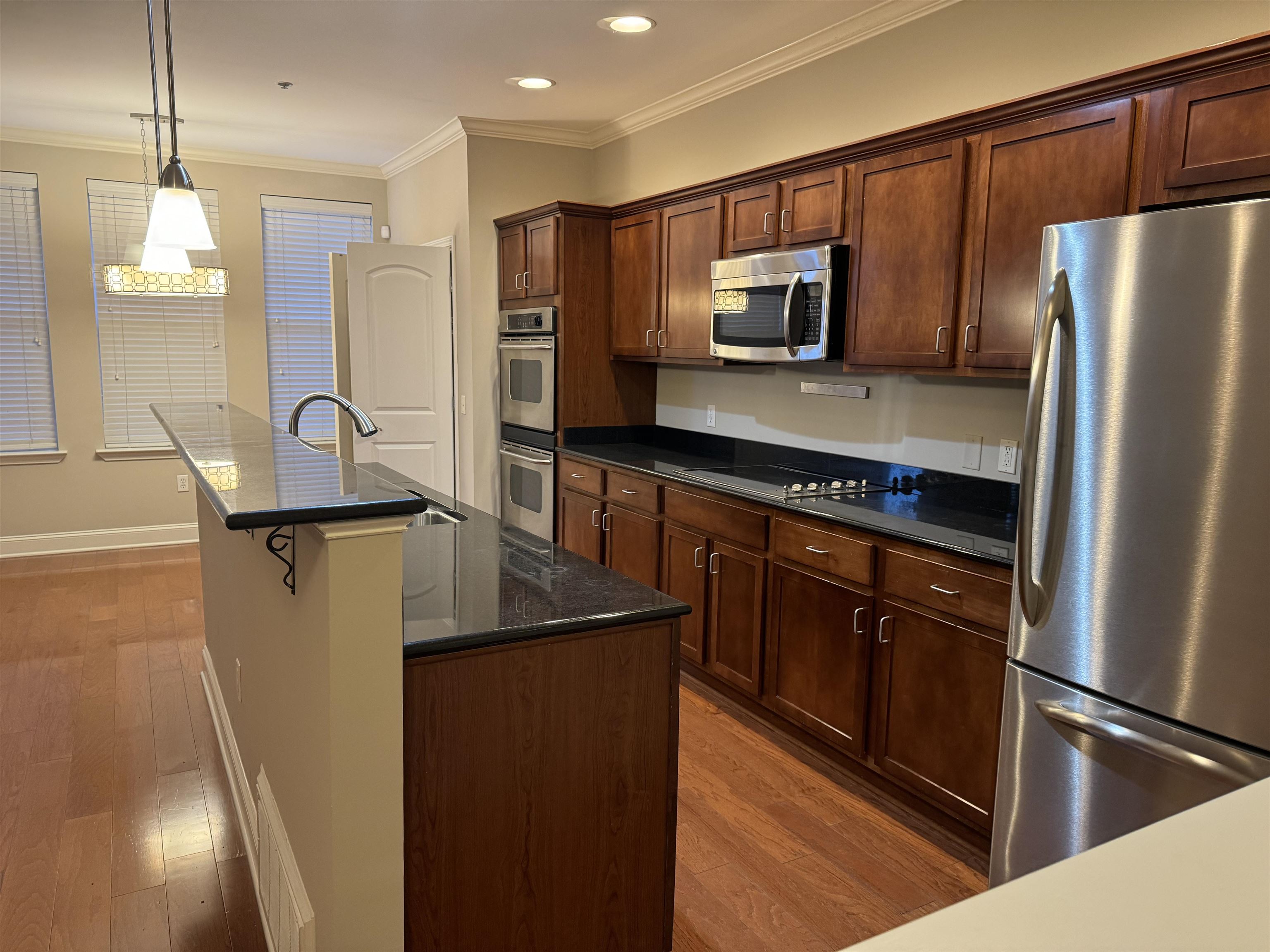 70 West Carolina Avenue, Unit 105 Memphis, TN 38103 - Photo 2 of 40 a kitchen with stainless steel appliances granite countertop a refrigerator a stove and a sink with wooden floor