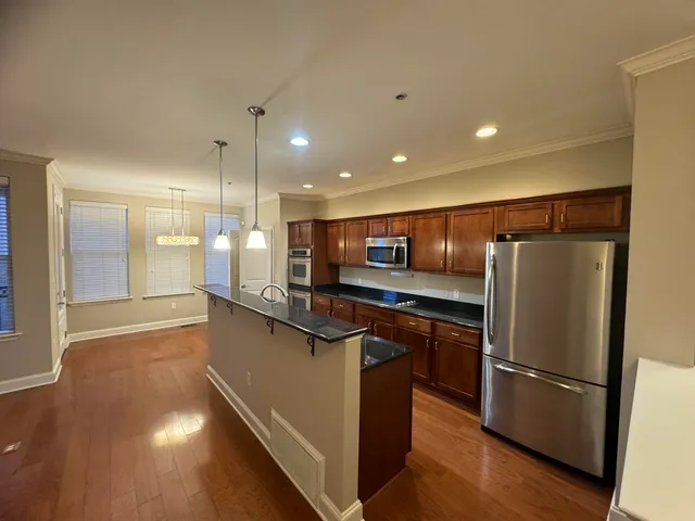 a kitchen with stainless steel appliances granite countertop a refrigerator a sink and a stove