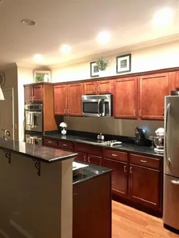 a kitchen with stainless steel appliances granite countertop a sink stove and cabinets