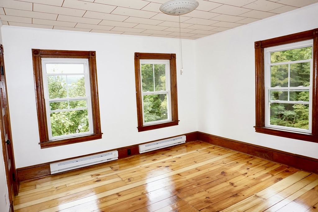 4 Carpenter Road Monson, MA 01057 - Photo 18 of 29 a view of an empty room with wooden floor and a window