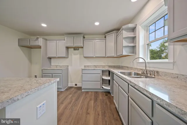 a kitchen with granite countertop a sink stove and cabinets