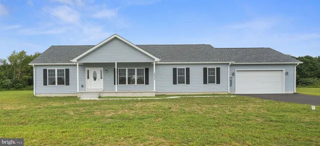 a front view of a house with a garden and yard