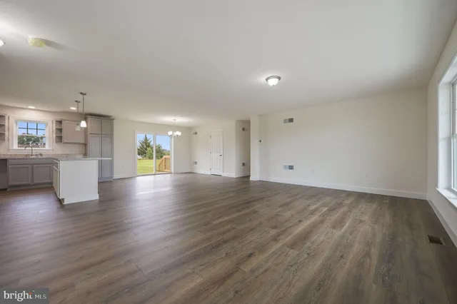 wooden floor in an empty room with a kitchen