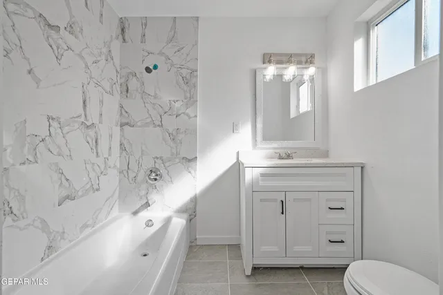 a bathroom with a double vanity sink mirror and toilet