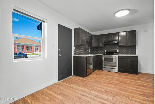 a kitchen with stainless steel appliances granite countertop a refrigerator and a stove