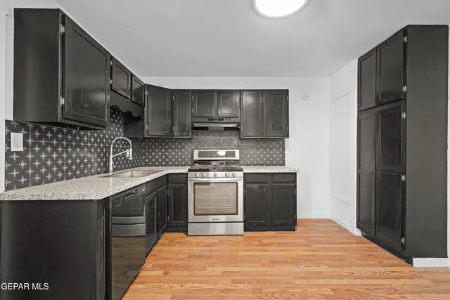 a kitchen with stainless steel appliances granite countertop a sink stove and refrigerator