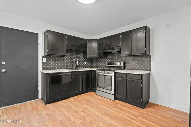 a kitchen with stainless steel appliances granite countertop a stove a sink and a microwave