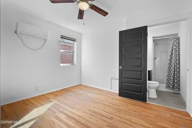 wooden floor in an empty room with a bathroom