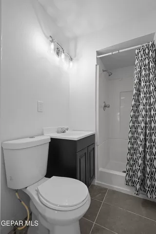 a white toilet sitting next to a shower curtain