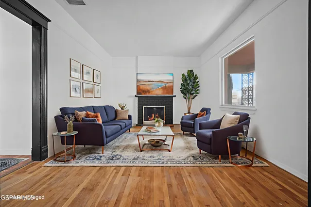 a living room with furniture a fireplace and wooden floor