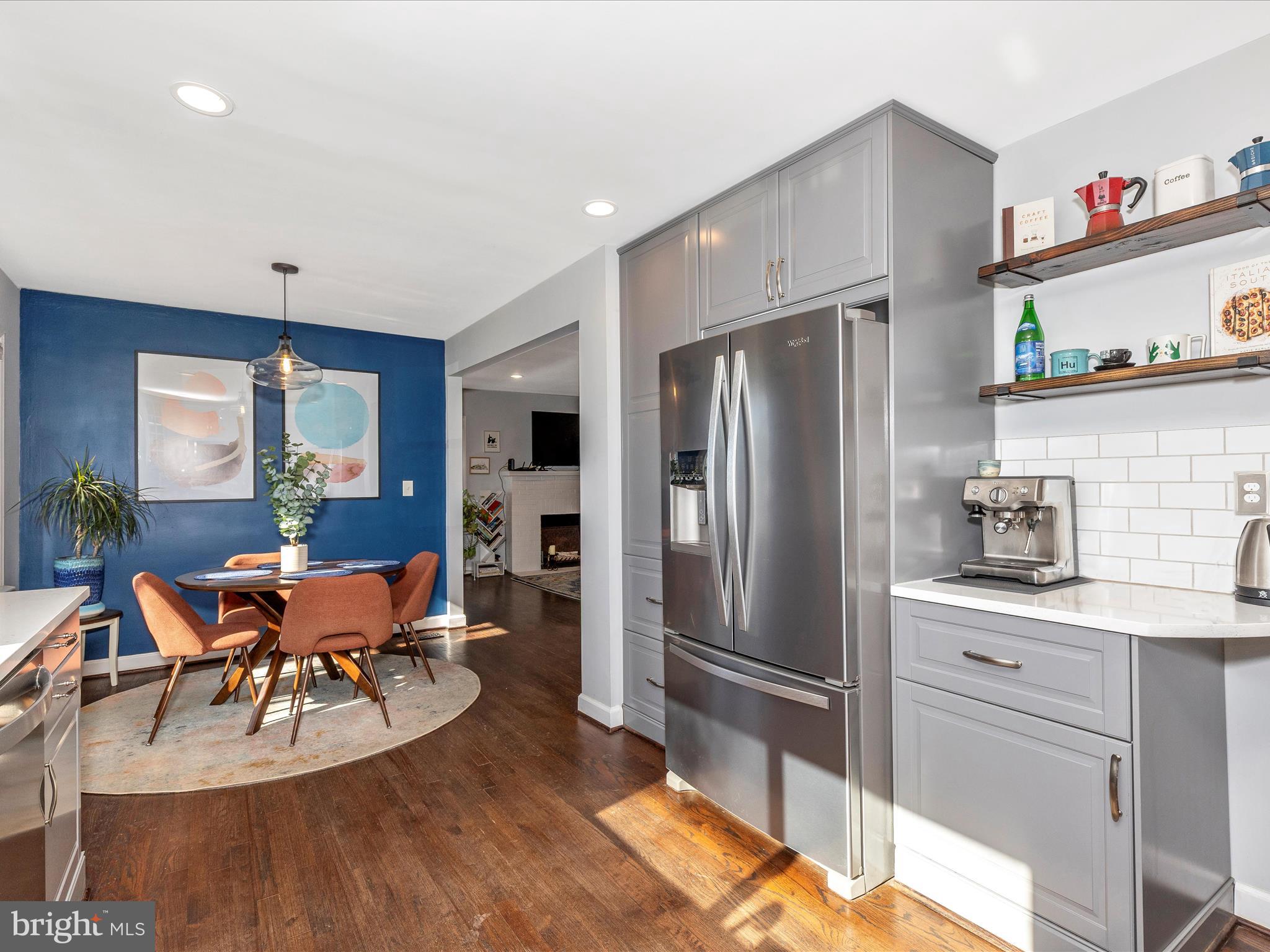 207 Thomas Avenue Frederick, MD 21701 - Photo 15 of 60 a kitchen with stainless steel appliances a refrigerator a stove a dining table and chairs with wooden floor