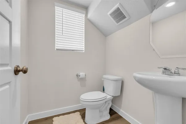 a bathroom with a toilet a sink and mirror