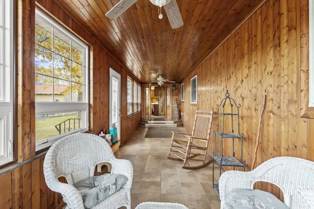 a living room with furniture a fireplace and a floor to ceiling window