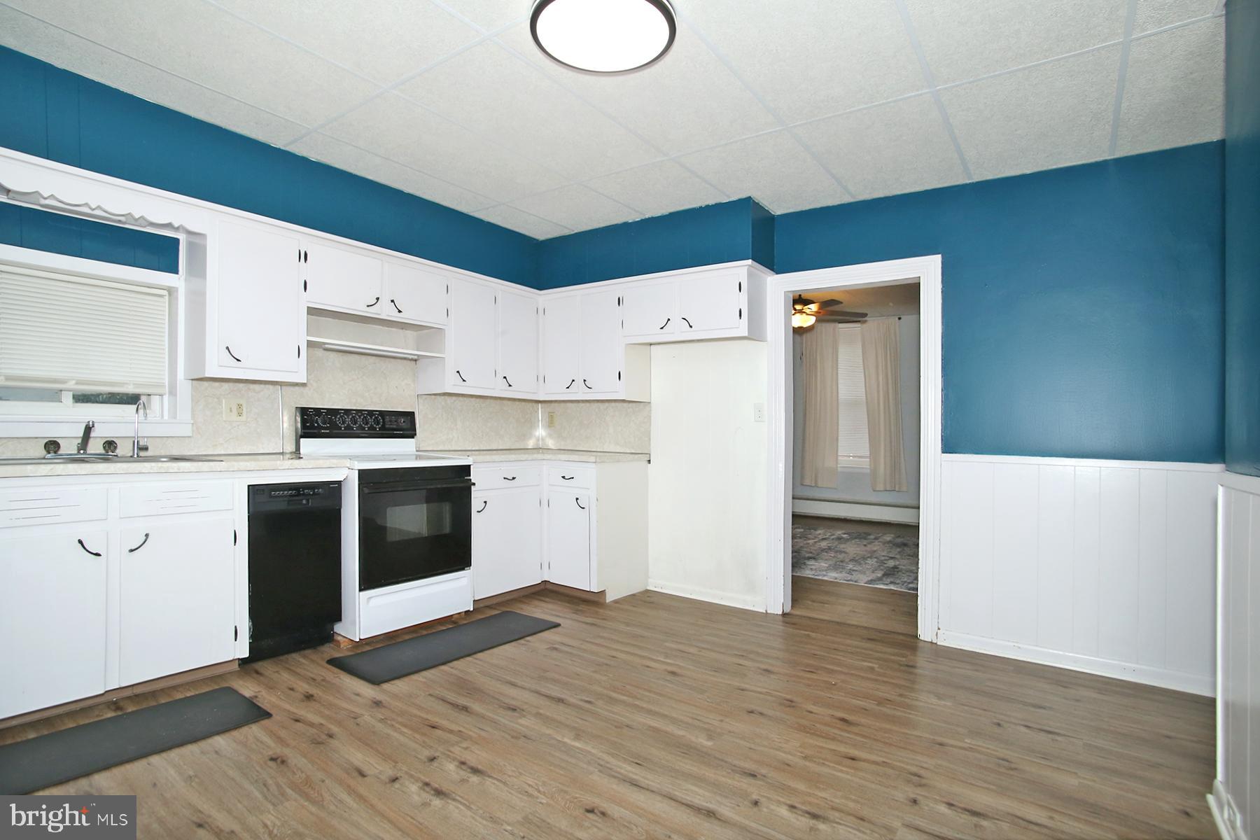133 West Market Street Jonestown, PA 17038 - Photo 11 of 43 a kitchen with granite countertop a refrigerator a stove a sink and white countertops with wooden floor